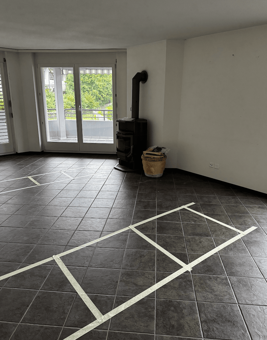 Wohnraum mit dunklem Plattenboden und Cheminée vor dem Umbau
